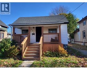 A small white house with a brown front porch.