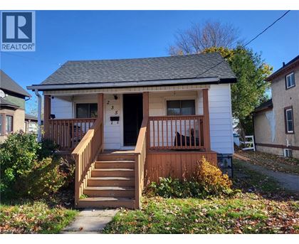 A small white house with a brown front porch.