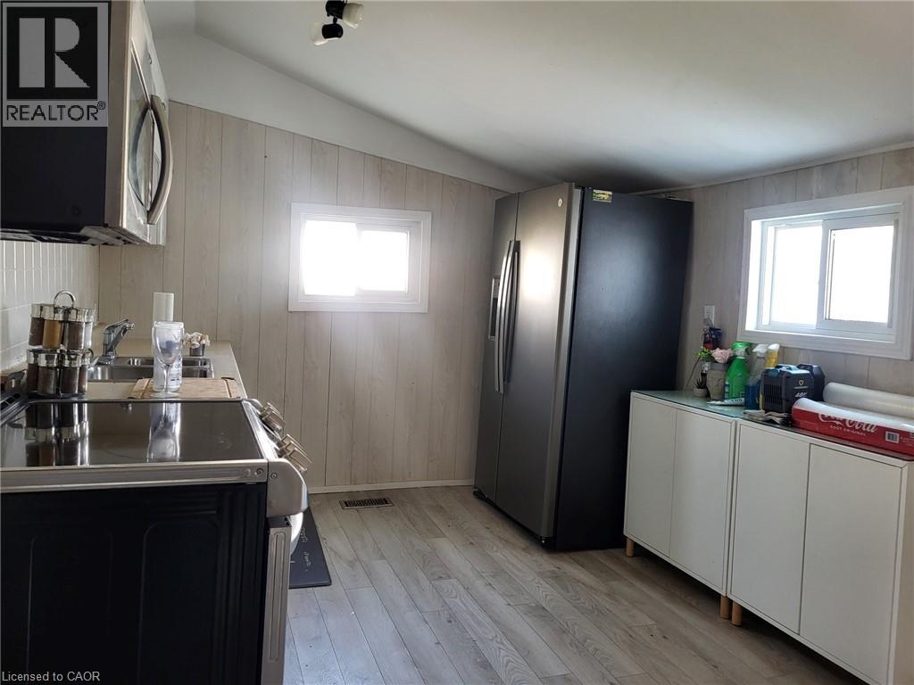 A kitchen with a black refrigerator and white cabinets.