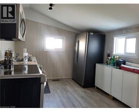 A kitchen with a black refrigerator and white cabinets.