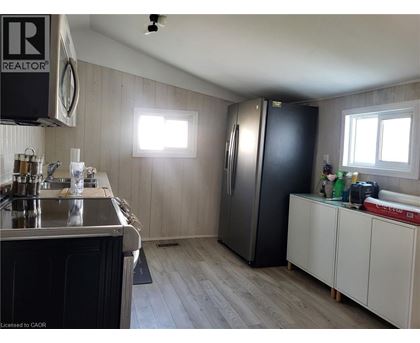 A kitchen with a black refrigerator and white cabinets.