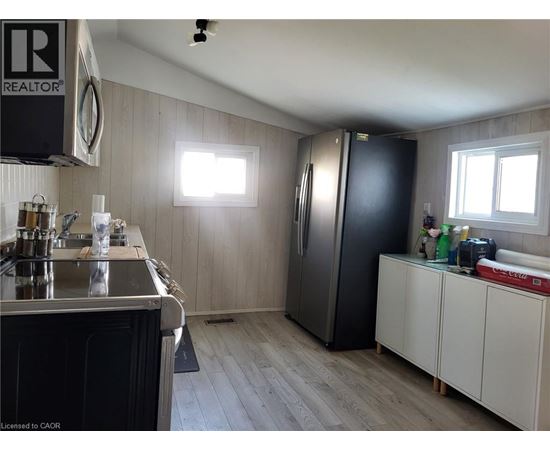 A kitchen with a black refrigerator and white cabinets.