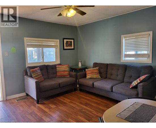 A living room with two grey couches and a ceiling fan.