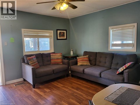 A living room with two grey couches and a ceiling fan.