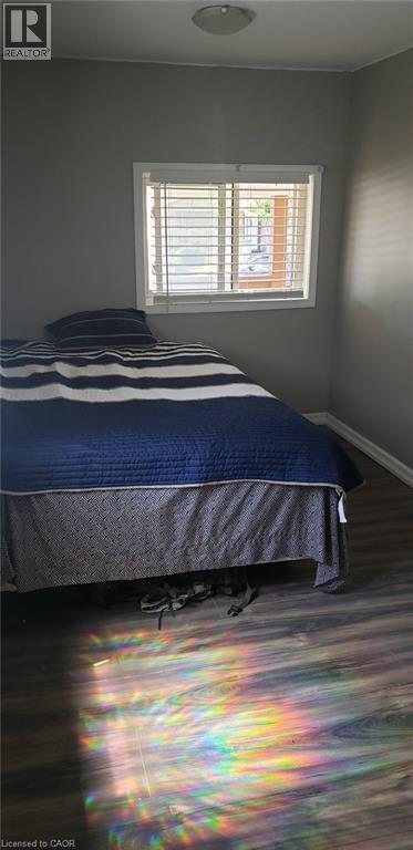 A bedroom with a bed and a window with blinds.