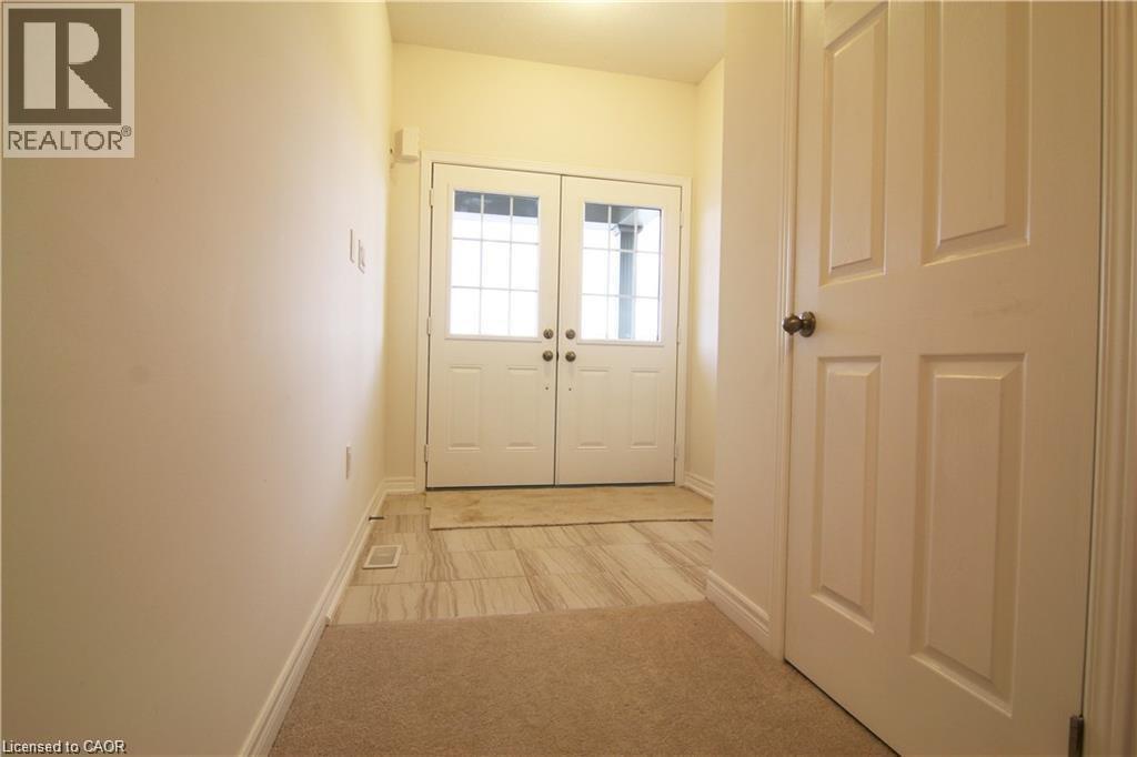 A hallway with a carpeted floor and white walls.