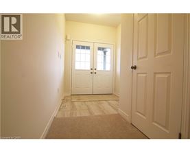 A hallway with a carpeted floor and white walls.