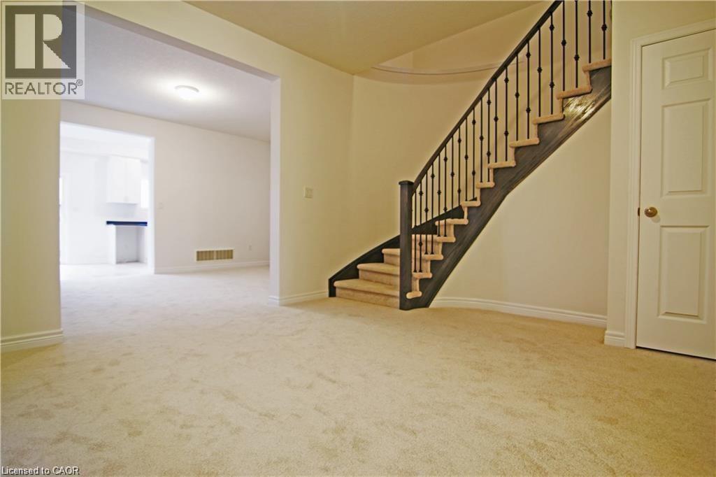 A spacious room with a staircase leading to the upper floor.