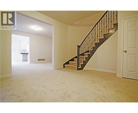 A spacious room with a staircase leading to the upper floor.