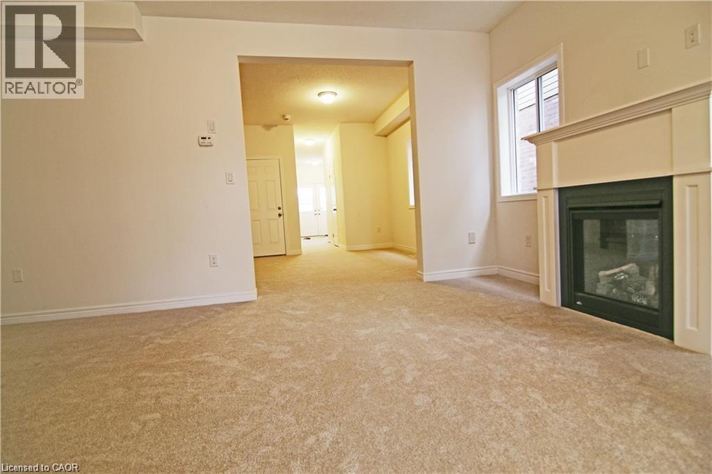 A living room with a fireplace and a carpeted floor.