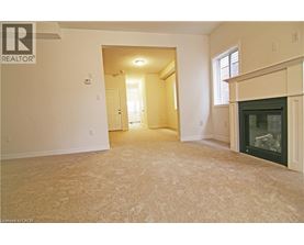 A living room with a fireplace and a carpeted floor.