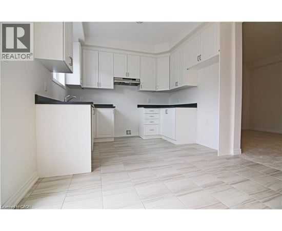 A kitchen with white cabinets and a black countertop.