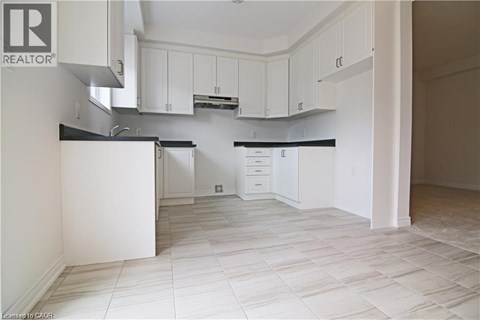 A kitchen with white cabinets and a black countertop.