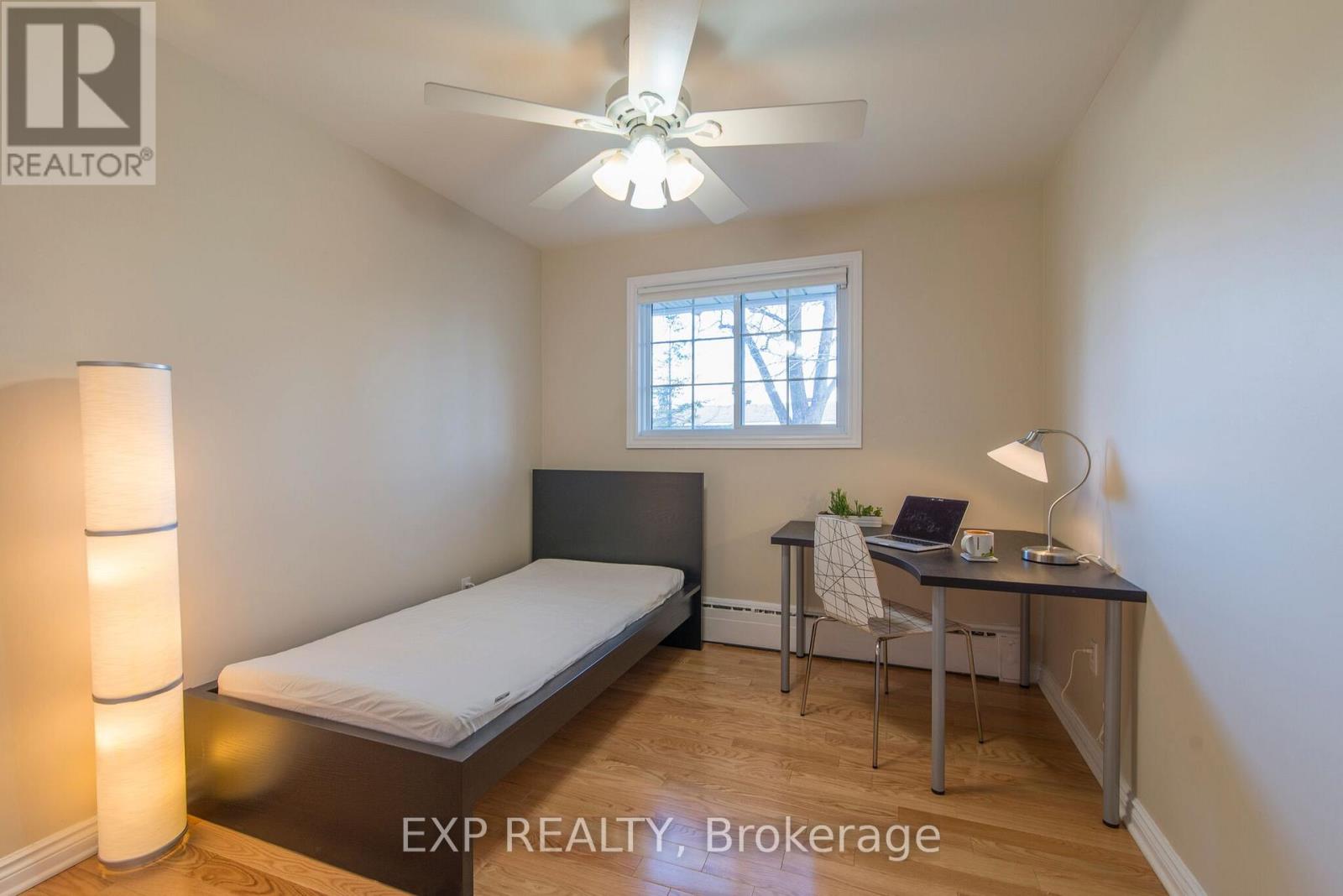 A bedroom with a bed, desk, and chair.