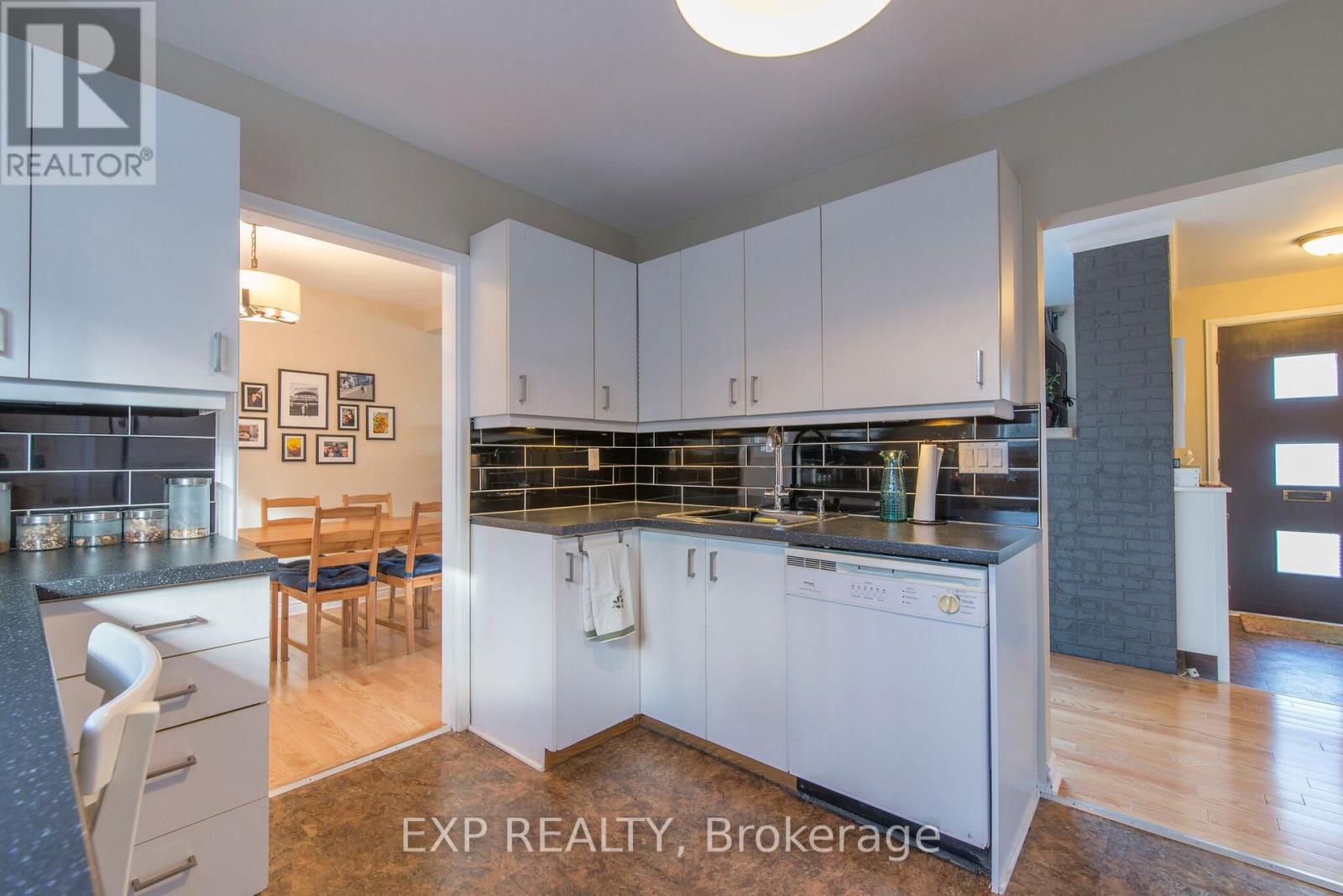 A kitchen with white cabinets and a black countertop.