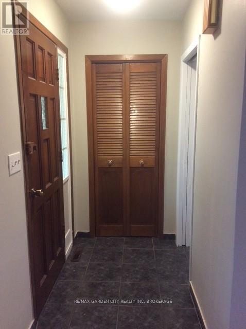 A hallway with a wooden door and a white door.