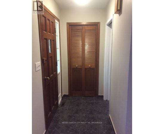 A hallway with a wooden door and a white door.