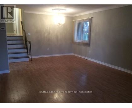 A room with wooden flooring and a window with blinds.