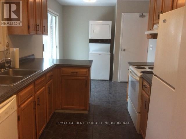 A kitchen with wooden cabinets and a white fridge.
