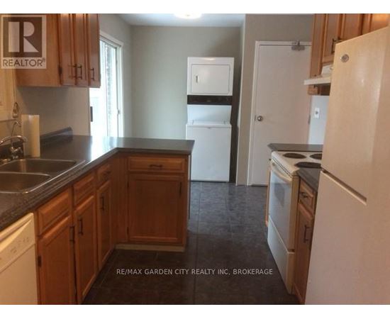 A kitchen with wooden cabinets and a white fridge.