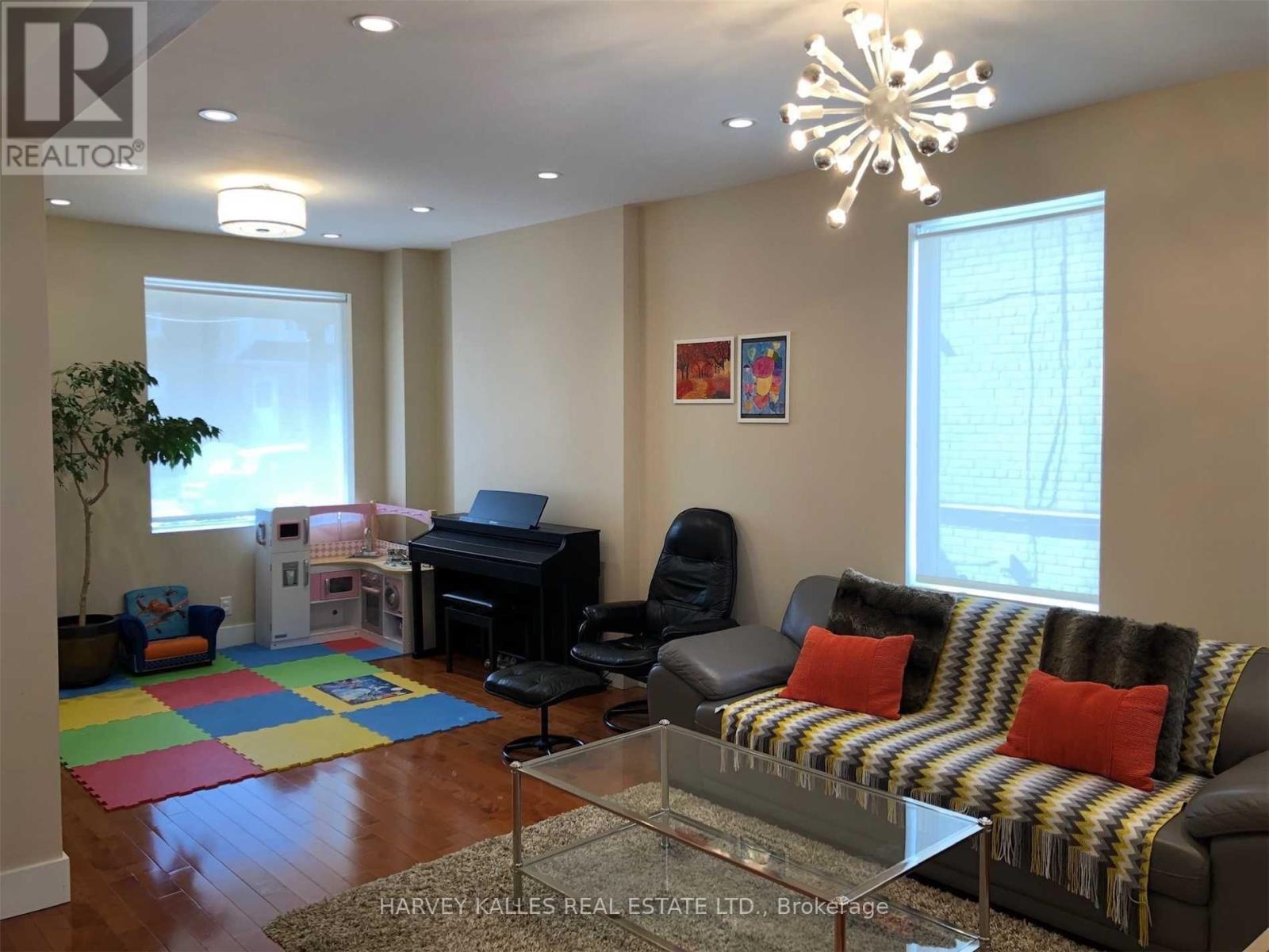 A living room with a couch, chair, and a piano.