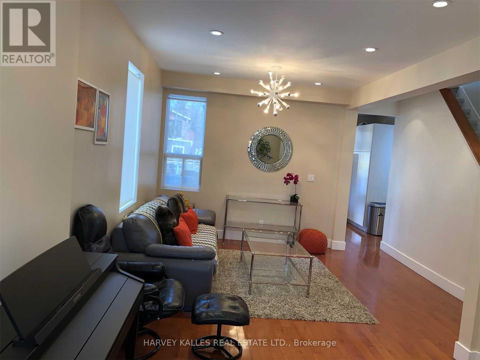 A living room with a grey couch and a glass coffee table.
