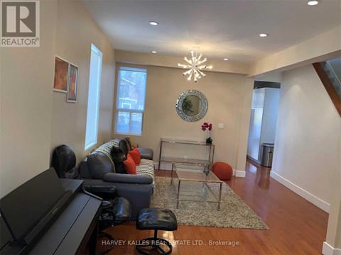 A living room with a grey couch and a glass coffee table.