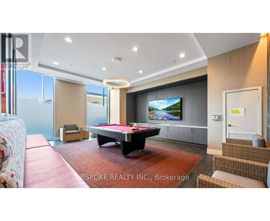 A living room with a pool table and a television.