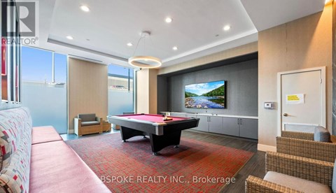 A living room with a pool table and a television.