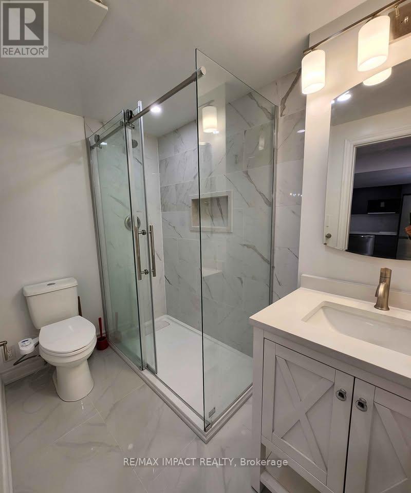 A bathroom with a toilet, sink, and shower.