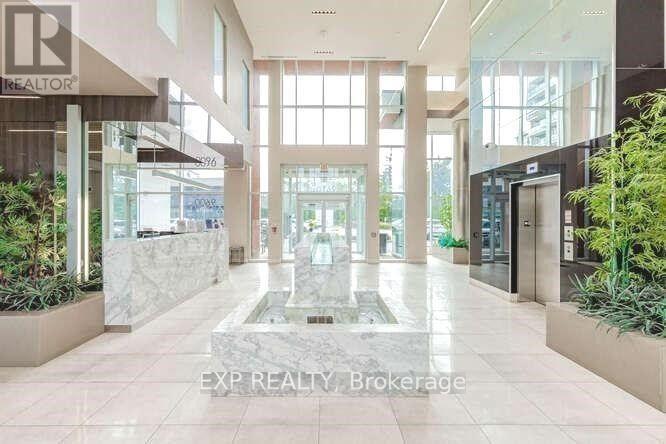 The lobby of a building with a fountain in the center.