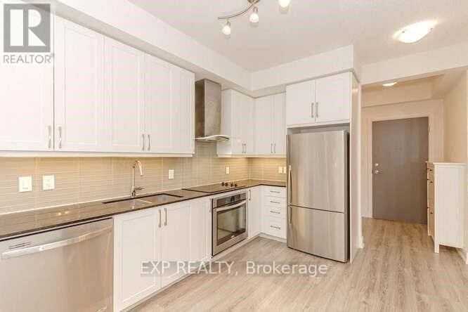 A kitchen with white cabinets and stainless steel appliances.