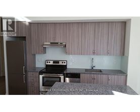 A kitchen with a refrigerator, oven, and sink.