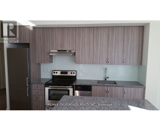 A kitchen with a refrigerator, oven, and sink.