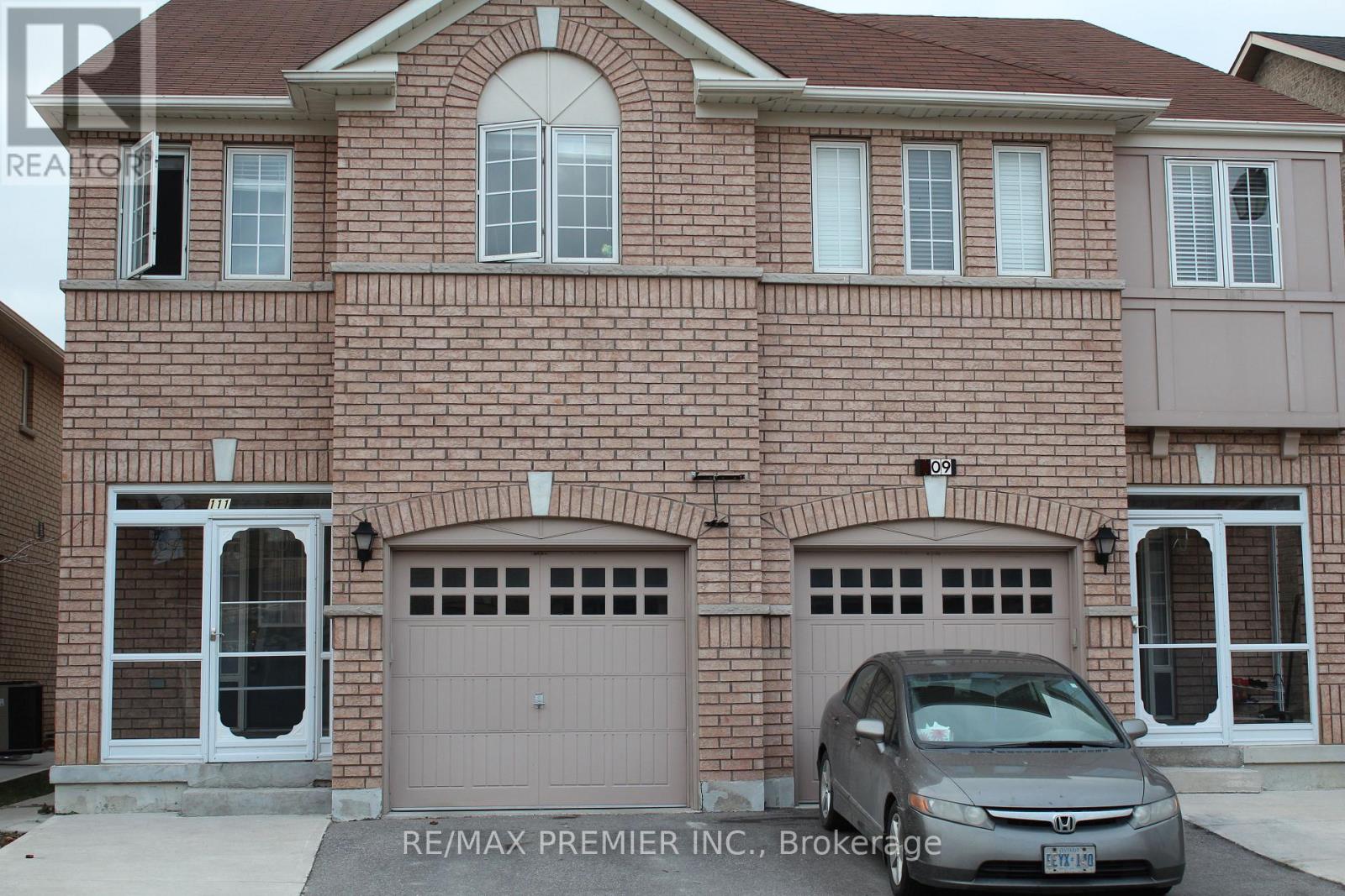 A brick house with a car parked in front.