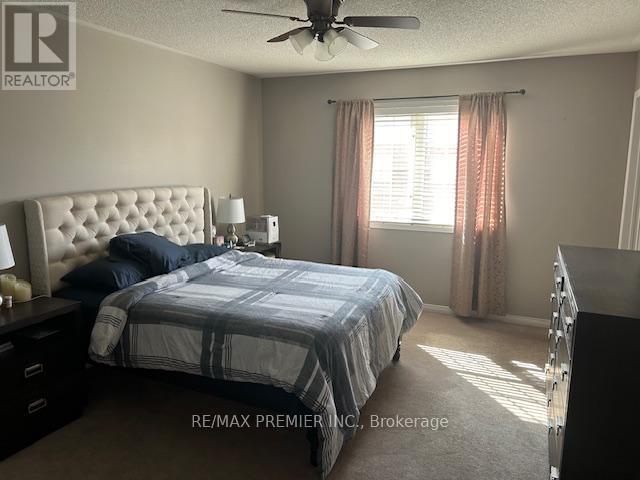 A bedroom with a large bed and a ceiling fan.