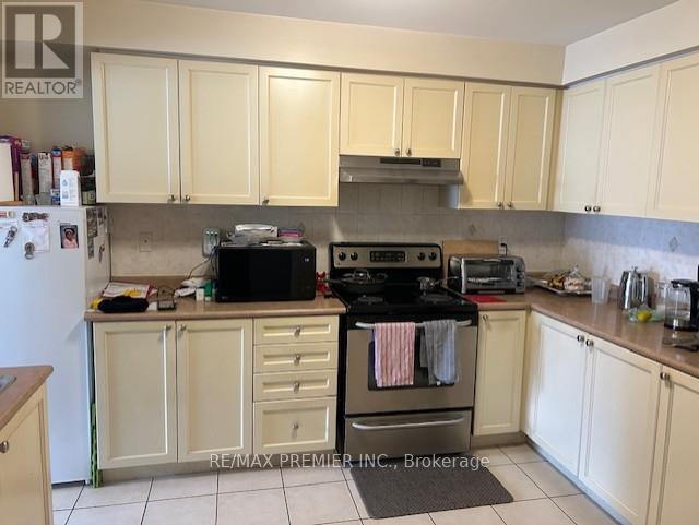 A kitchen with white cabinets and a black stove top.
