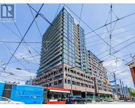 A tall building with many windows is under construction with a blue RE/MAX sign in the foreground.