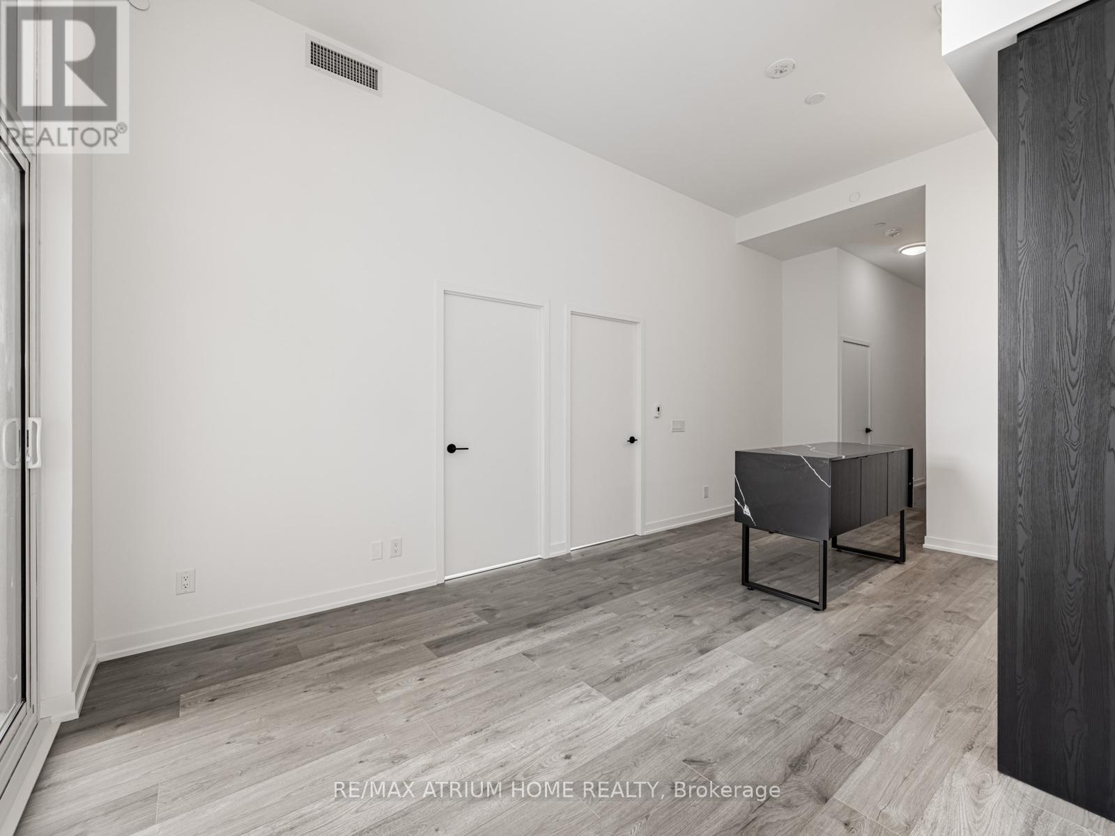 A spacious room with a pool table and a wooden floor.