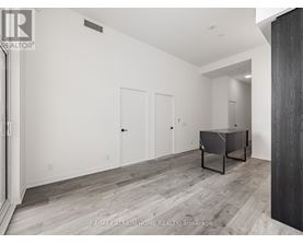 A spacious room with a pool table and a wooden floor.