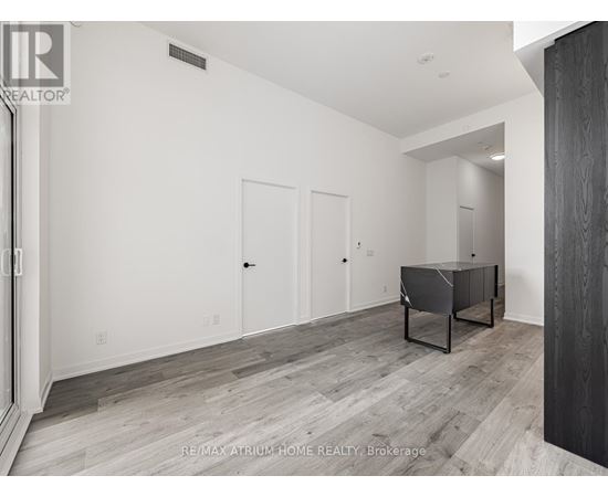 A spacious room with a pool table and a wooden floor.