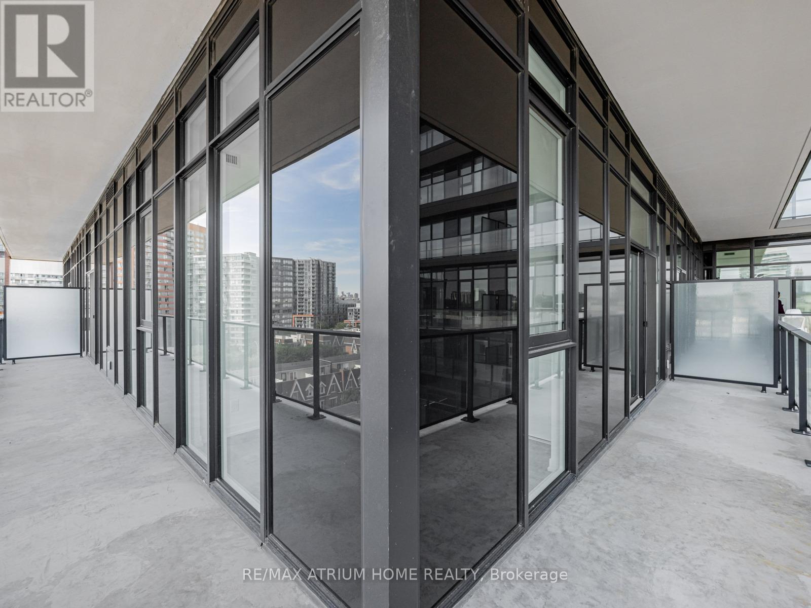 A modern interior space with large glass walls and a view of the city.