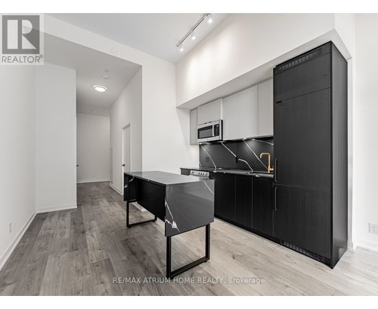A modern kitchen with black cabinets and a black table.