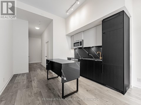 A modern kitchen with black cabinets and a black table.