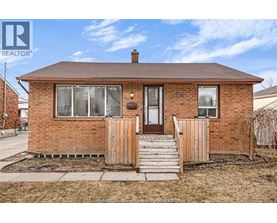 A small brick house with a brown door and a small porch.