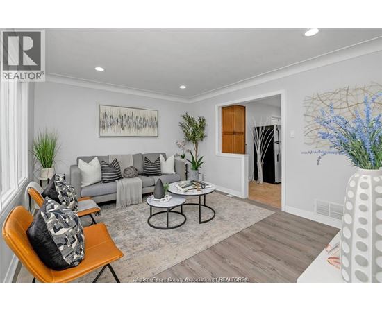 A living room with a grey couch, a coffee table, and a painting on the wall.