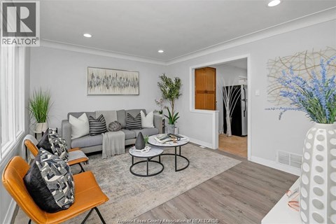 A living room with a grey couch, a coffee table, and a painting on the wall.
