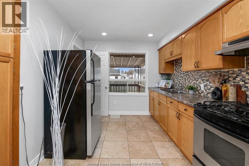 A kitchen with wooden cabinets and a black refrigerator.