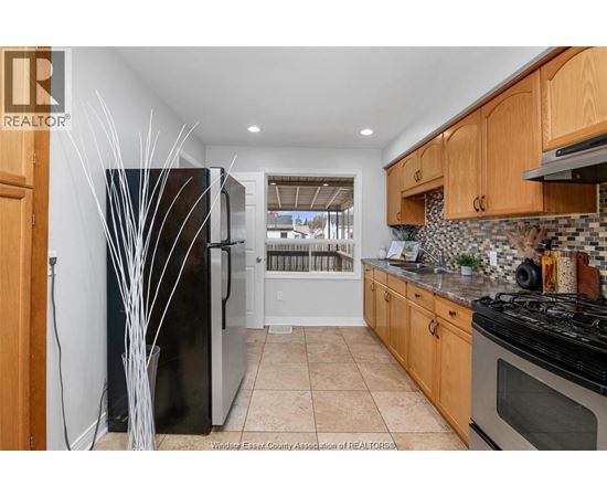 A kitchen with wooden cabinets and a black refrigerator.