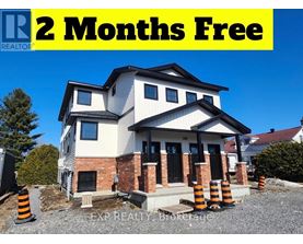 A house under construction with a sign offering 2 months free.